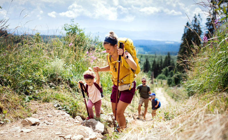 Mutter und Kinder wandern auf einem Berg