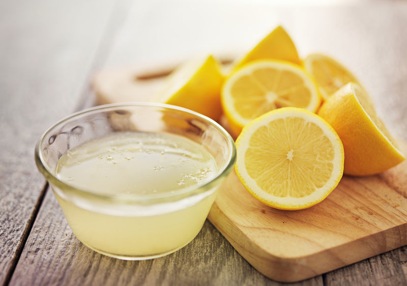 Nagelpilz bekämpfen: Schale mit Zitronensaft und Zitronen